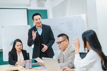 Asian businessman present start up project to expert investor, Teamwork group of multicultural business team solving problems, discussing business idea with skyscraper at modern business lounge