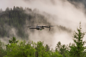 Fototapeta na wymiar Drone with camera flying over mountain fields.