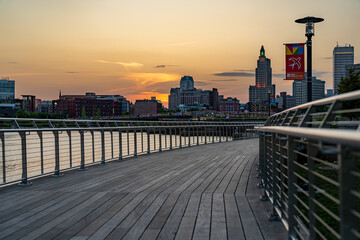 Stainless steel railing along a public exterior wooden board walk in an urban setting.