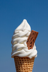 An ice cream cone with a blue sky background