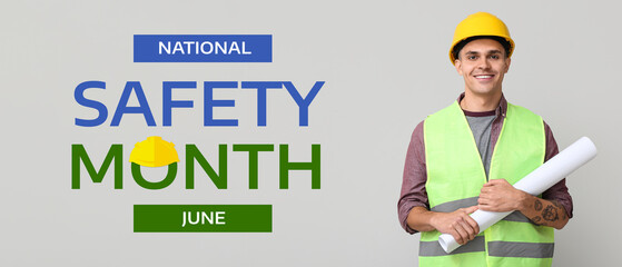 Young male engineer with blueprint on grey background