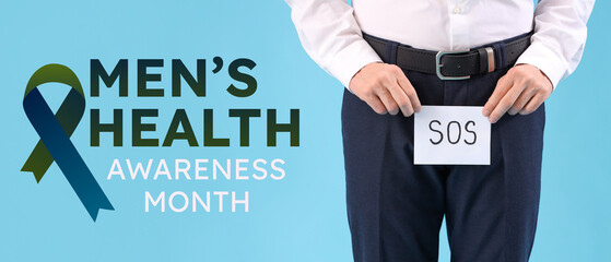 Young businessman holding paper with word SOS on blue background, closeup. Prostate cancer...