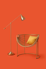 Golden armchair with pillow and lamp on red background