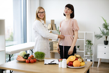 Efficient dietitian calculating body mass index for assessing healthy weight. Mature woman in...