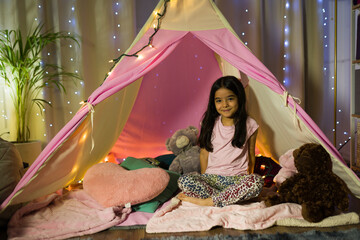 Young hispanic girl has a fun evening in her bedroom tent with fairy lights © AntonioDiaz