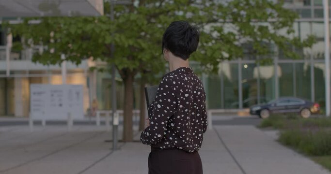 Portrait of woman, expert business coach, standing in sunglasses against the backdrop of modern building. Concept of professional coaching, business expertise, and urban lifestyle. Dynamic background