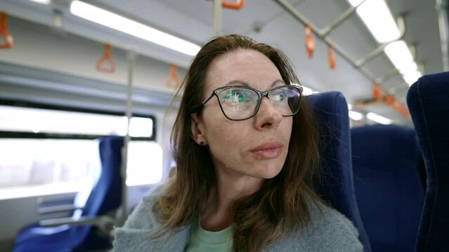 In the cozy atmosphere of the transport salon, a middle-aged woman in modern glasses expresses her unique style and personality.