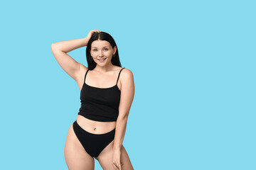 Body positive young woman on blue background