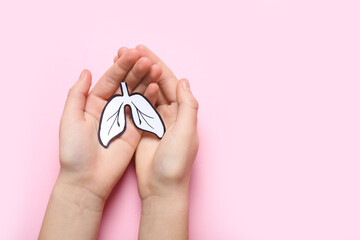 Female hands with paper lungs on pink background