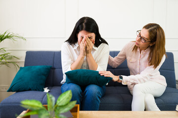 Woman psychologist offers comfort to a crying patient during a private therapy session, depicting a moment of genuine mental health care