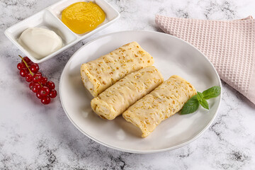 Homemade stuffed pancakes with honey and cream sour