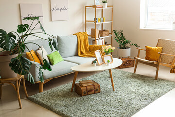 Interior of stylish living room with sofa, posters and frames on table