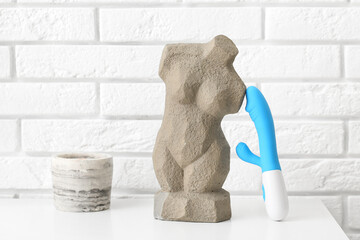 Vibrator from sex shop and decor on table in room