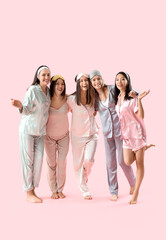 Fototapeta premium Young women in pajamas hugging on pink background. Hen Party