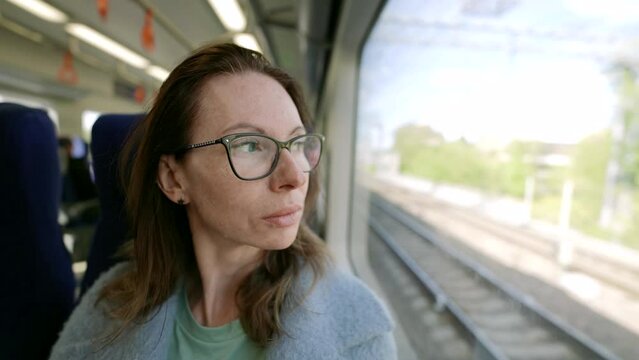 In public transport, amid a cozy atmosphere, a middle-aged woman in fashionable glasses radiates style and uniqueness.