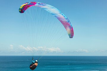 Paraglider flies in front of the ocean