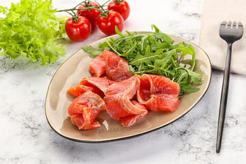 Sliced salmon with fresh arugula