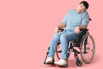 Young man sitting in wheelchair on pink background. National Cerebral Palsy Awareness Month