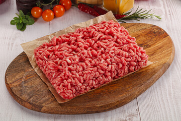 Raw minced beef meat over board