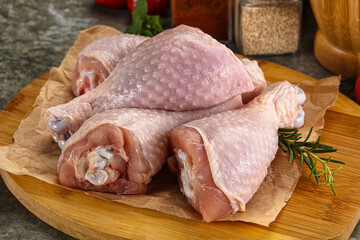 Raw uncooked chicken drumsticks over board