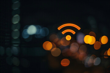 Obraz premium Orange Wi-Fi symbol over a blurred background with bokeh lights, representing connectivity in an urban setting