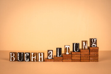 Accounting word in German. Wooden alphabet letters on a light background