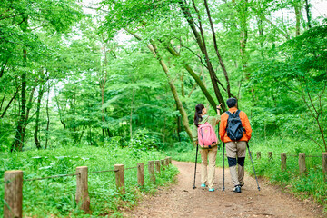 初夏の山でトレッキングするシニア夫婦