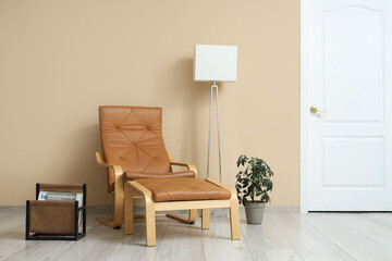 Interior of living room with leather armchair, lamp and magazine stand