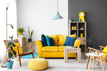 Interior of stylish living room with yellow sofa and armchairs