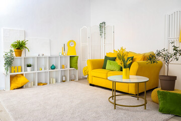 Interior of stylish living room with yellow sofa, table and shelf unit