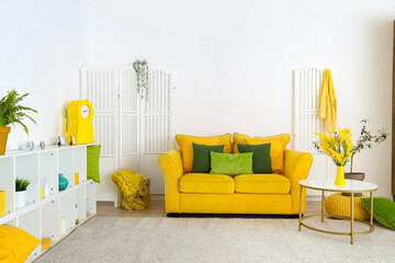 Interior of stylish living room with yellow sofa, table and shelf unit