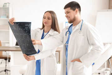 Doctors studying x-ray image of spine at hospital