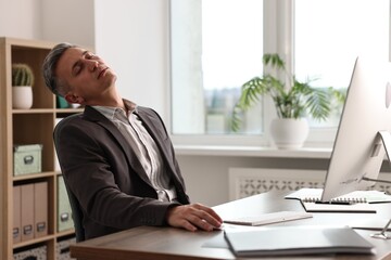 Man snoozing at wooden table in office