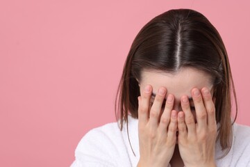 Woman suffering from hair loss problem on pink background. Space for text
