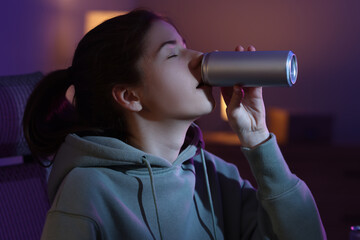 Girl with can of energy drink at home