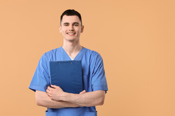 Portrait of smiling medical assistant with clipboard on beige background. Space for text