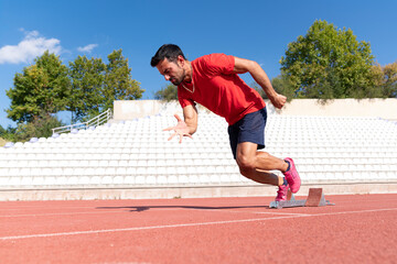 Stadium, man running and start block of athlete on a runner and arena track for sprint