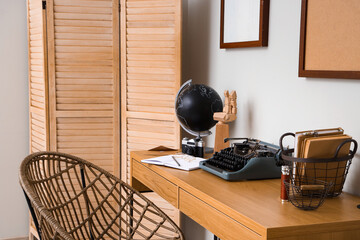 Author's workplace with vintage typewriter and globe in office