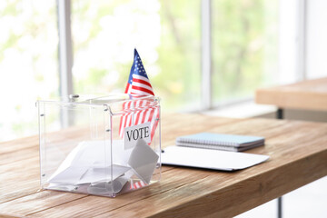 Voting ballot box with USA flag on table at polling station, closeup