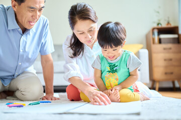 2歳の孫とお絵描きをするシニア夫婦