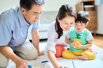 2歳の孫とお絵描きをするシニア夫婦