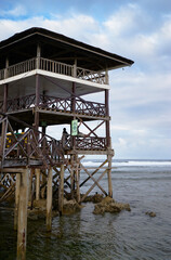 Wooden bungalow with terrace on piles on the sea beach.