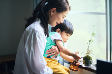 苔玉のお世話を孫に教えるシニア夫婦