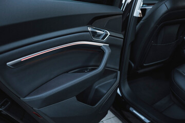 Modern black subcompact electric crossover SUV with black interior. Details interior.