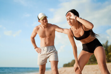 Care and support. Sport lifestyle concept. Young strong man helping his tired girlfriend while...