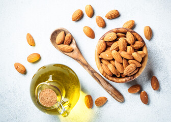 Almond nuts and almond oil at white background. Healthy fat, omega 3 sources. Flat lay with copy space.