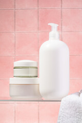 Bathroom with Cosmetic products at glass shelf at pink background.