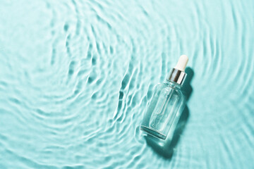 Serum bottle in the water with waves. Top view with copy space.