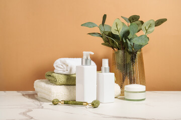 Natural cosmetic, towels and vase with flowers in the bathroom.