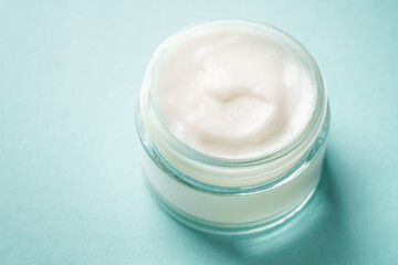 Cream jar on blue background. Skin care product. Close up.